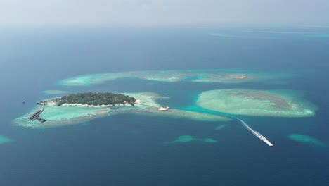 Asombrosa-Vista-Aérea-De-Las-Islas-Maldivas-Con-Un-Bote,-Agua-Turquesa,-Palmeras-Y-Playas-De-Arena-Blanca