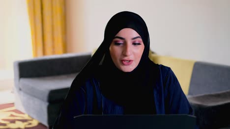 Mujer-En-Hijab-Abaya-Llamando-A-Través-De-Un-Teléfono-Móvil-Inteligente-Mientras-Trabaja-De-Forma-Remota