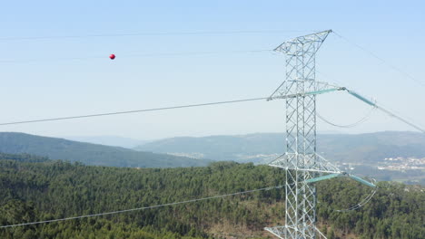 Electricity-power-grid-pylon-parallaxing-with-forest---Aerial-crane-down-shot