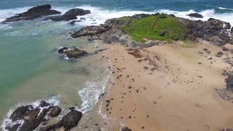 Frothy-Waves-Splashing-On-Green-Headland-With-Rocky-Outcrop-Near-Bonville-Headland-At-Sawtell-Beach-In-New-South-Wales,-Australia