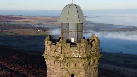 Darwen-Jubilee-tower-top-overlooking-Lancashire-hillside-misty-valley-moorland-countryside-aerial-descending