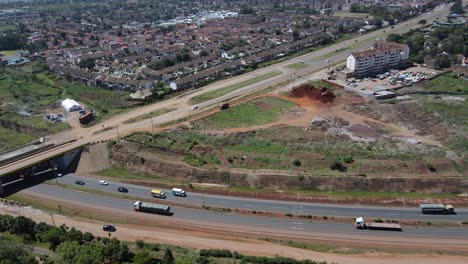 Vista-Aérea-Sobre-Un-Sitio-De-Trabajo-De-Reurbanización-Entre-Una-Carretera-Y-Edificios-Modernos-En-Nairobi