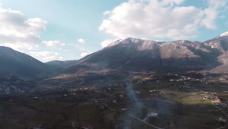 Aerial-landscape-view-over-mountain-villages,-on-a-sunny-evening,-in-Italy