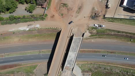 Aerial-view-over-a-highway-road-bridge,-with-vehicles-speeding-by,-in-Nairobi,-Kenya