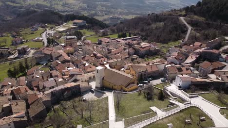 Aerial-landscape-view-over-Pietraroja,-a-village-on-top-of-a-hill,-in-Italy,-on-a-sunny-day
