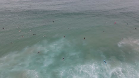 Aerial-View-Of-People-In-Surfboards-Floating-In-Blue-Ocean-Of-Bondi-Beach-In-Sydney,-New-South-Wales,-Australia