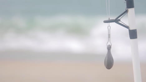 Weight-Hangs-from-Fishing-Rod-on-Beach-Coastline