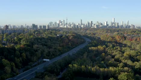 Cinematic-drone-tilts-up-over-the-Don-Valley-in-Toronto,-Canada-to-reveal-the-CN-Tower-skyline