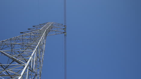 Klarer-Blauer-Himmel-Unterbrochen-Von-Stromversorgungsturm---Low-Angle-Wide-Shot