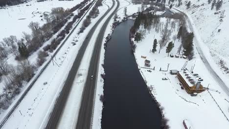 AERIAL---Camera-tilts-up-revealing-snowstorm-above-highway-and-river
