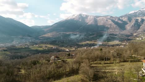 Vista-Aérea-Del-Paisaje-Sobre-Los-Pueblos-De-Montaña,-En-Un-Día-Soleado,-En-Italia