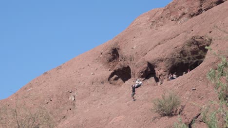 Menschen-Tauchen-Aus-Dem-Ikonischen-Loch-Im-Felsen-Wahrzeichen-Im-Papago-Park,-Phoenix,-Arizona-Auf