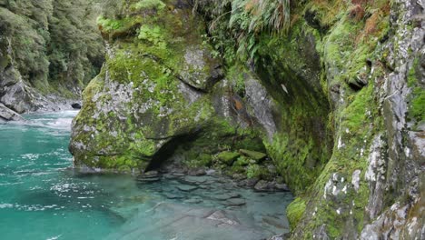 Tilt-down-mossy-sculpted-limestone-rock-to-clear-river-water-below