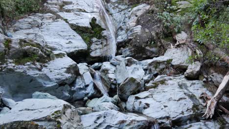 Ein-Kleiner-Kaltwasserstrom-Bahnt-Sich-Einen-Weg-Durch-Einen-Glatten-Kalksteinwasserfall