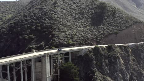 Car-drive-on-Bixby-Canyon-Bridge-near-Big-Sur-coast-in-California