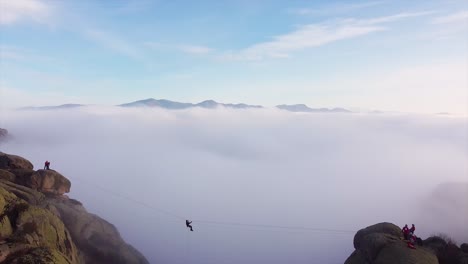 Emergency-rescue-team-using-a-zip-line-on-saving-mission-above-thick-fog-drone-shot