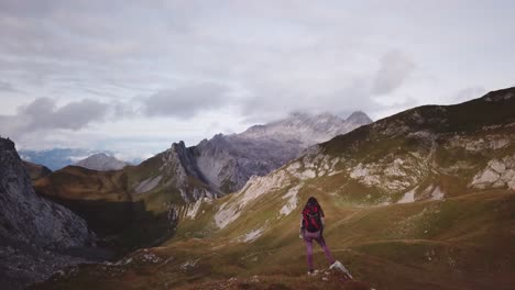 Woman-is-standing-in-the-Alps---slow-passing-by-Parallax-drone-flight