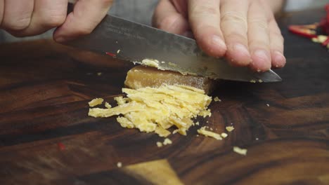 Chopping-brown-sugar-with-kitchen-knife-on-wooden-cut-board