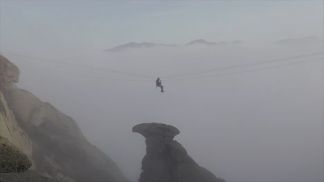 Rock-climber-working-on-a-zip-line-on-a-rescue-mission-on-a-foggy-day