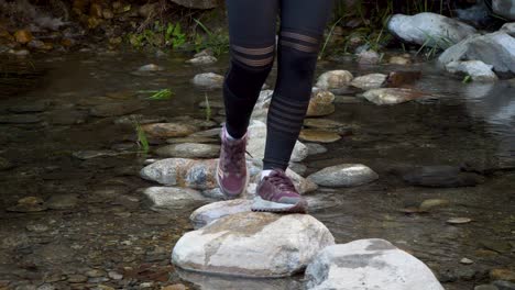 Young-Woman-Skipping-Over-Boulders-in-Creek-CLOSE-UP