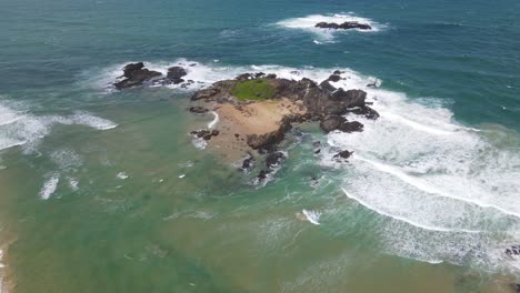 Drone-Towards-Rocky-Headland-With-White-Waves-Splash-Through-Rocks-At-Sawtell-Beach-Near-Bonville-Peninsula-In-New-South-Wales,-Australia