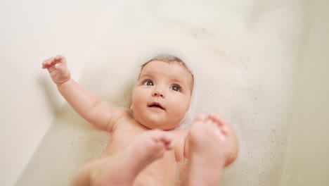 little-baby-girl-lying-on-her-back-in-the-bathroom-all-in-foam