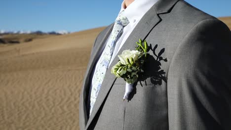 Groom-Wearing-Boutonniere-On-Grey-Suit-With-Floral-Tie