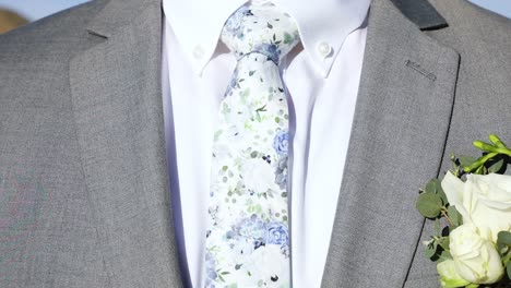 Boutonniere-Pinned-On-Suit-Jacket-Of-Groom-With-Floral-Tie