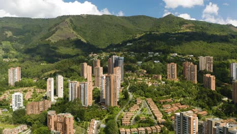 Beautiful-Aerial-View-of-Luxury-Apartment-Buildings-in-Medellin,-Colombia-Built-into-Andes-Mountains-on-Clear-Day