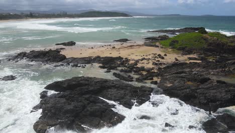Black-And-Mossy-Rocks-Hit-By-Waves-At-Sawtell-Beach-In-North-Coast-Of-New-South-Wales,-Australia
