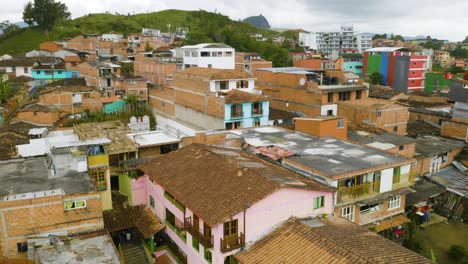 Tiro-Aéreo-Ascendente-Revela-Casas-De-Ladrillo-En-La-Ciudad-Pobre-De-Guatape,-Colombia