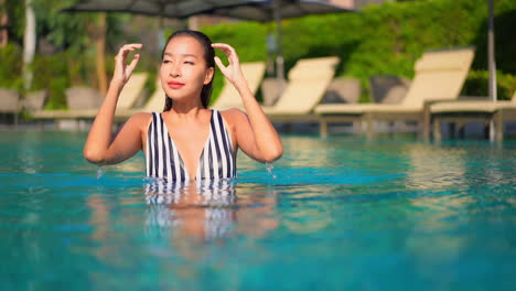 Moderne-Asiatische-Frau,-Die-Sich-Im-Schwimmbad-Entspannt-Und-In-Die-Kamera-Slomo-Schaut