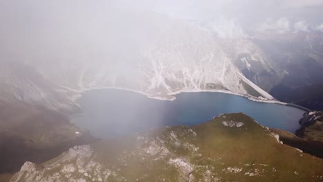 Vertical-Drone-flight-in-fog-Alps-Lünersee-Lake-in-Austria-Vorarlberg