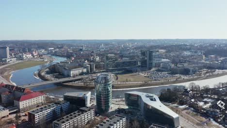 Antenne:-Rotierende-Aufnahme-Von-Vilnius-Panorama-Mit-Flussufer-Neris-Und-Bürogebäuden-Im-Hintergrund