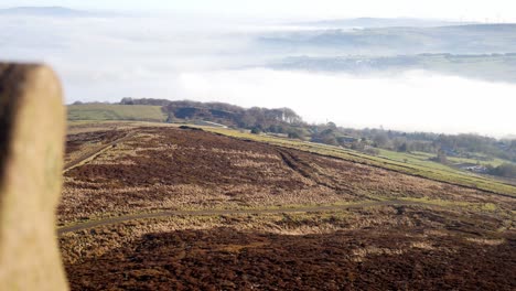 Fog-clouds-passing-across-moorland-countryside-valley-viewpoint-from-stone-tower-battlement-wall-dolly-right-reveal