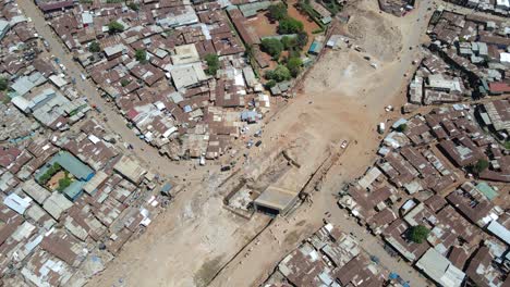 Drohnenansicht:-Straßenbau-In-Den-Slums-Von-Kibera,-Kenia---Menschen,-Die-Auf-Den-Schlechten-Straßen-Von-Kibera-Spazieren-Gehen