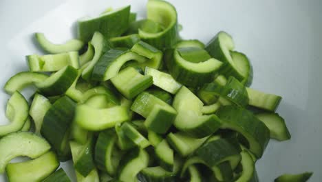 Adding-cucumber-into-deep-white-bowl