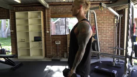 Tattoo-man-muscles-in-home-gym-doing-bicep-curls-strict