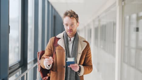 Handsome-young-curly-man-with-ticket-and-credit-card