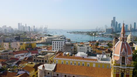 Birds-Eye-Aerial-View-of-Colorful-Cartagena-Cathedral-with-Skyline,-Port-in-Background