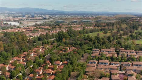 Aerial-view-over-a-park-and-housing-looking-towards-the-mountains-in-Irvine,-California