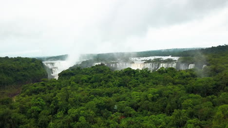 Aerial---Iguazu-Falls-and-river-in-Misiones,-Argentina,-wide-forward-reveal-shot