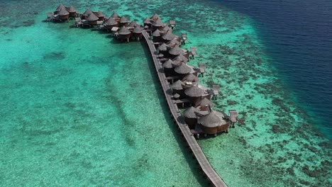Aerial-view-of-beautiful-Maldives-island-water-villa-bungalows,-Nika-Island-4K