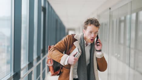 An-angry-young-man-walks-down-the-hall-and-shouts-on-the-phone