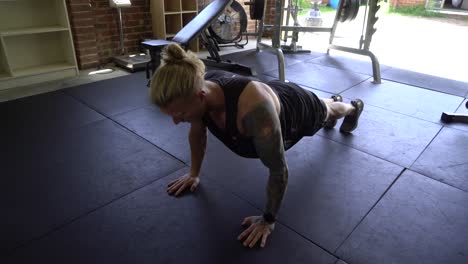 Tattoo-man-muscles-in-home-gym-doing-push-ups-workout
