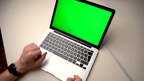 Man-Using-Chroma-key-screen-laptop-computer-on-desk-at-home-stock-video
