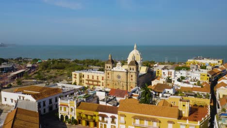 Drohne-Fliegt-über-Farbenfrohen-Kolonialgebäuden-In-Richtung-Kuppelkirche-In-Cartagena,-Kolumbien