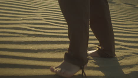 Barefooted-person-walking-in-the-beautiful-dessert-sand-during-a-sunset