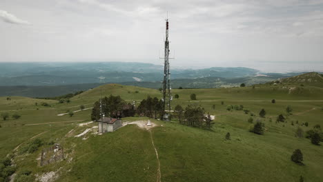 Drone-shot-of-a-radio-tower-on-top-of-mountain-Slavnik-with-a-view-on-nearby-mountains-and-Adriatic-sea