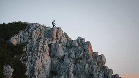 Shot-of-the-hiker-standing-at-the-end-of-mountain-ridge-on-mountain-Peca-in-the-early-morning-at-the-sunrise
